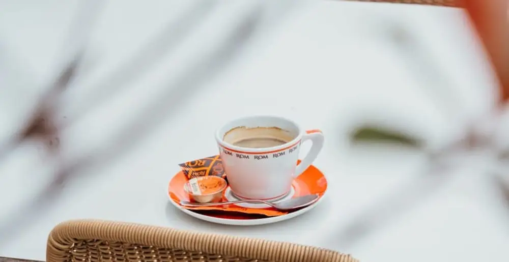 Kopje ROM-koffie op een oranje schoteltje