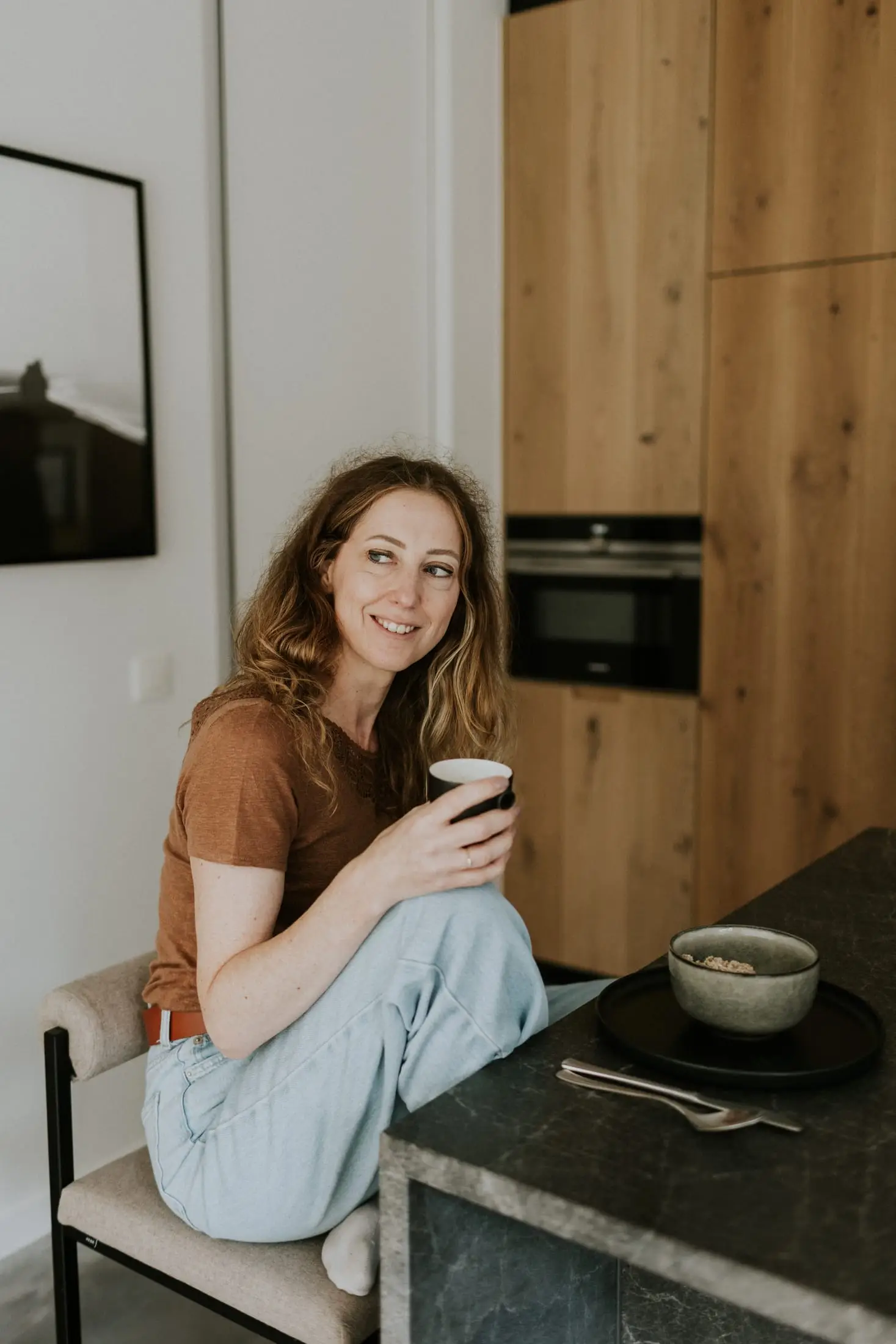 Vrouw drinkt koffie aan het keukeneiland